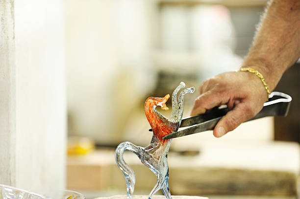Glassmaker finishing horse ornament ** many almost identical glass horses are made each day** Venetian glassmaker on the famous island of Murano placing the hot glass figure of a horse to cool and set.More like this hand blown glass stock pictures, royalty-free photos & images
