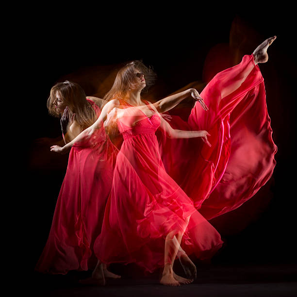 istock Female Dancer in red dress build patterns on black 174833118