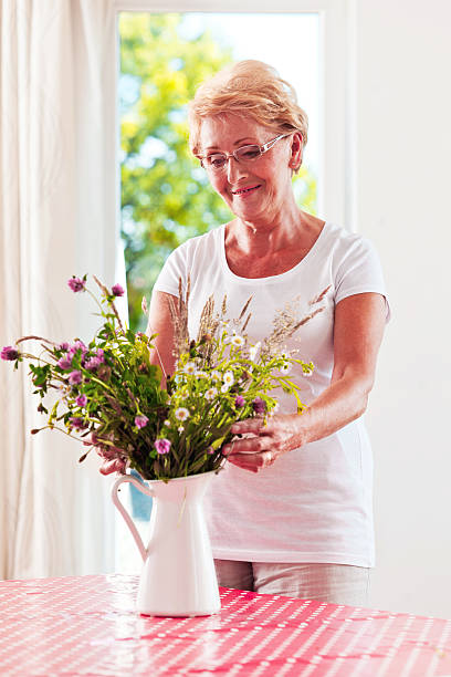 istock Senior woman arranging flowers 174833482