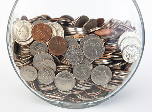 Fish bowl full of US coins. Horizontal.