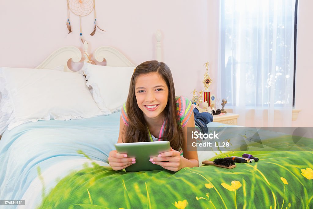 Chica con tableta Digital yacer en la cama - Foto de stock de Vista de frente libre de derechos