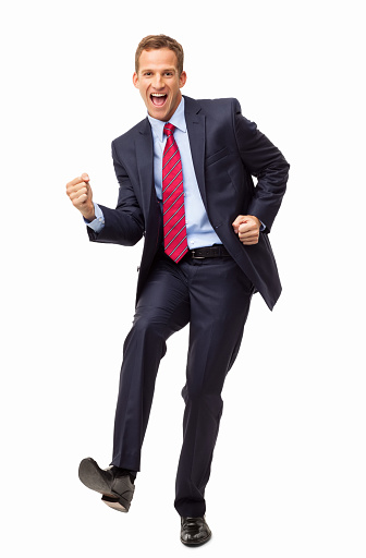 Full length portrait of an excited young business entrepreneur cheering with clenched fists. Vertical shot. Isolated on white.