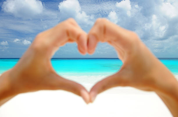 Natural Female Hands Heart Beautiful female hands shaping a heart in front of a beautiful secluded tropical beach. Nikon D3X. Converted from RAW. Focus on the horizon. couple hope sky blue stock pictures, royalty-free photos & images