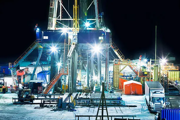 Photo of Illuminated Oil Drilling Tower at Night
