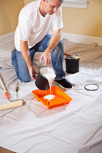 istock Man pouring paint into tray 174835428