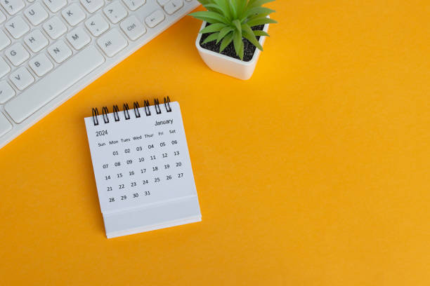 istock January 2024 desk calendar on yellow background. Directly above. Flat lay. 1748356584
