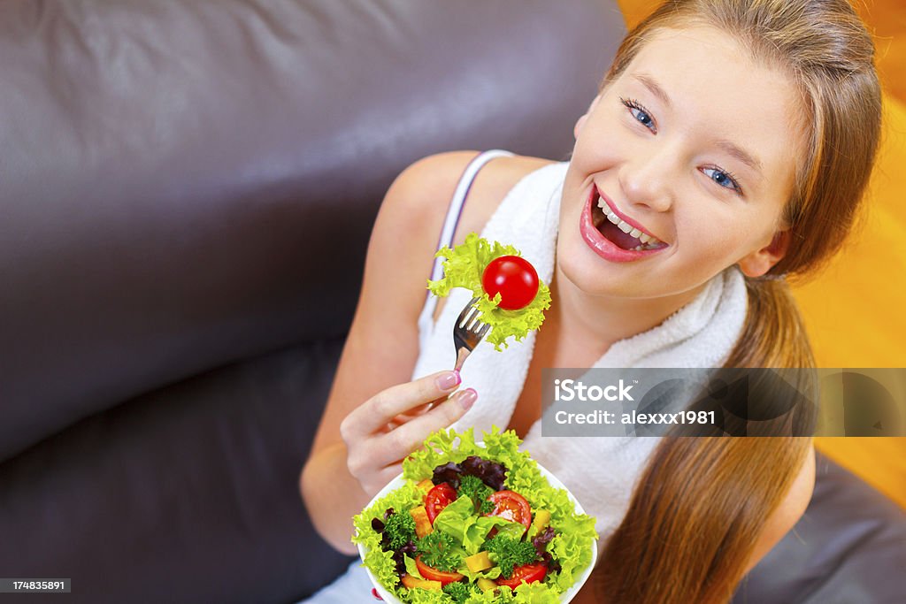 Retrato de niña adolescente sonriente comiendo ensalada de verduras frescas. - Foto de stock de Adolescente libre de derechos