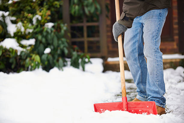 hombre de compensación de ruta con pala de nieve - shovel fotografías e imágenes de stock