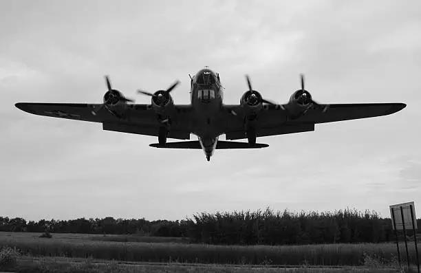 A B-17G passes low overhead as it is on final at the airport.