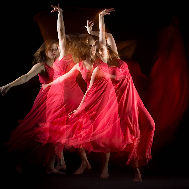 istock Female Dancer in red dress build patterns on black 174836194