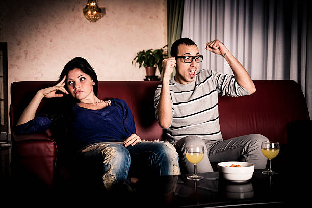 hombre aburrido y mujer viendo los deportes - television boredom men sofa fotografías e imágenes de stock