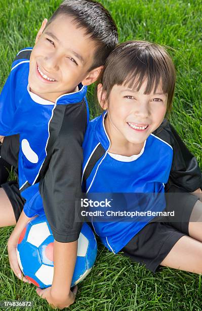 Foto de Menino E Menina Repousando Sobre Um Campo De Futebol e mais fotos de stock de 6-7 Anos