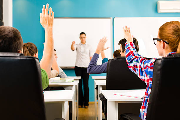 istock School children in classroom with raised hands 174837012