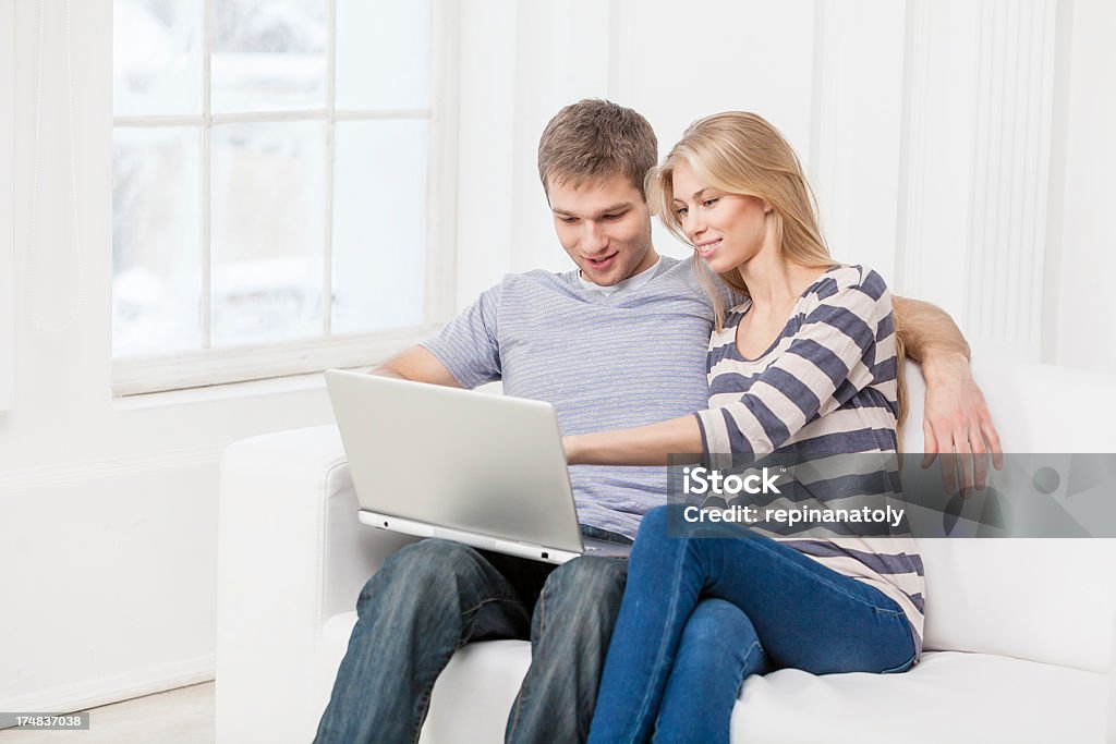 beautibul Junges Paar sitzt auf Sofa mit laptop - Lizenzfrei 20-24 Jahre Stock-Foto