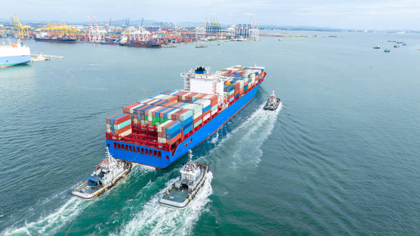 istock Cargo container ship carrying container and running with tug boat for import goods to cargo yard port to customs. concept logistics transportation and shipping. 1748371282