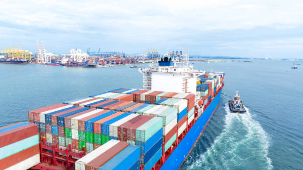 istock Cargo container ship carrying container and running with tug boat for import goods to cargo yard port to customs. concept logistics transportation and shipping. 1748371283