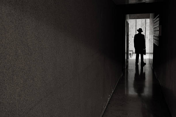 istock Man with hat standing in dark spooky entrence hall 174837224