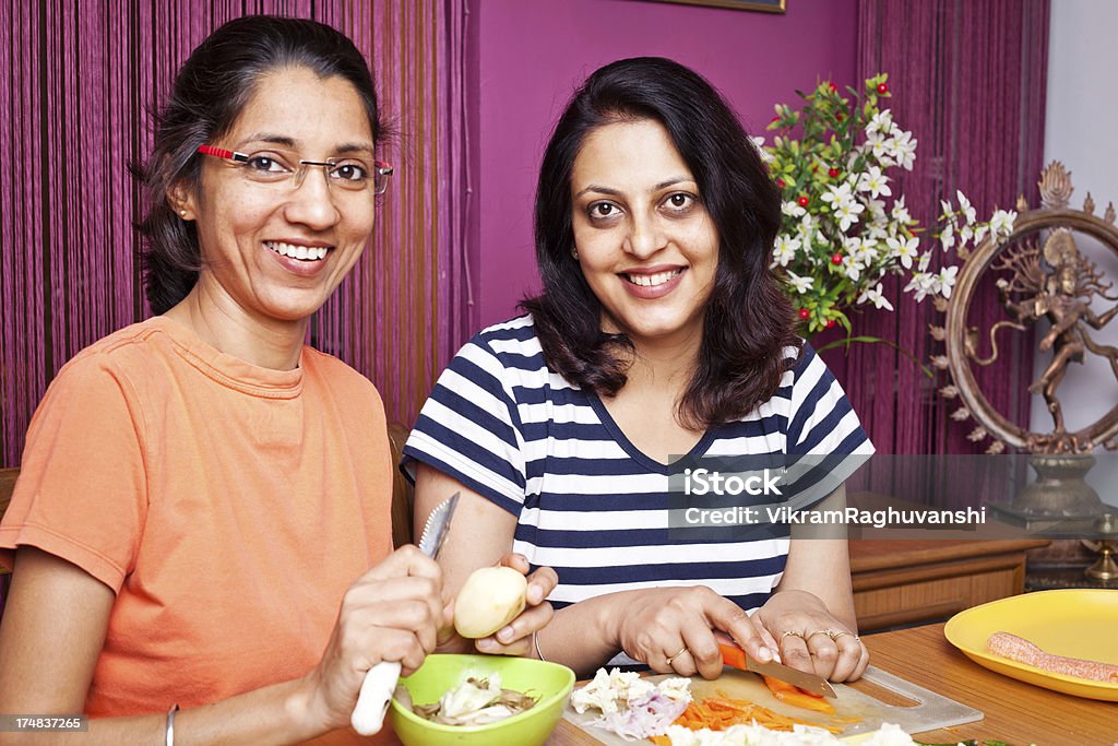 Две красочные Индийские женщины, Приготовление еды резки овощей - Стоковые фото 30-39 лет роялти-фри