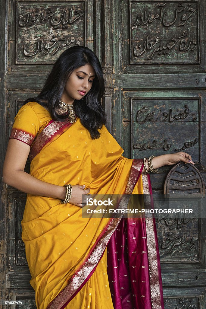 Temple of love Indian woman in traditional dress standing in front of monastery door. Culture of India Stock Photo