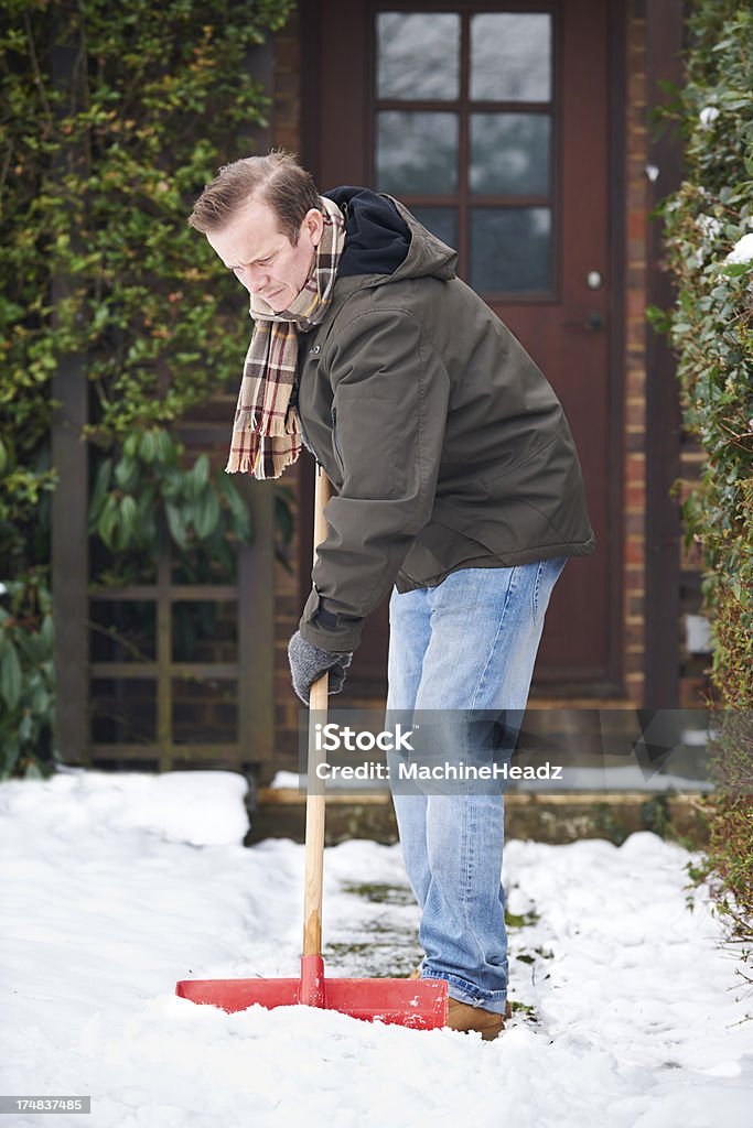 Man Clearing Snow From Path With Shovel Winter chores at home 40-49 Years Stock Photo