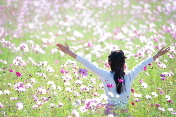 istock girl opens arms in flower field 1748375234