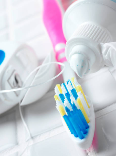 nić dentystyczna z szczoteczka do zębów i pasty - toothbrush pink turquoise blue zdjęcia i obrazy z banku zdjęć
