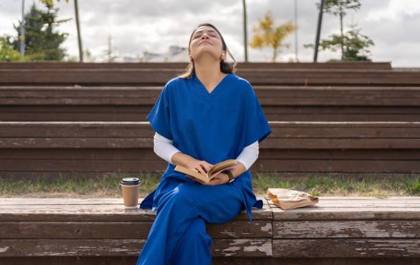 Healthcare Worker On A Lunch Break Healthcare Worker In Scrubs On A Lunch Break At Hospital doctor utensils stock pictures, royalty-free photos & images