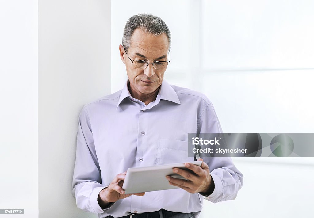 Maturo Uomo d'affari utilizzando tablet digitale. - Foto stock royalty-free di Abbigliamento da lavoro