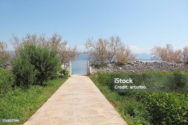 Photo libre de droit de Béton Allée Dans Le Jardin Avec Les Eaux Turquoise De Locéan Porte Clôture Trogir Croatie banque d'images et plus d'images libres de droit de Bleu