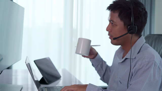 Businessman wearing headphones with microphone while talking on call.