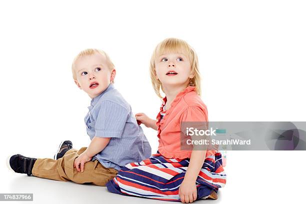 Zwei Kleine Kinder Sitzen Zusammen Wegsehen Im Copyspace Stockfoto und mehr Bilder von 2-3 Jahre