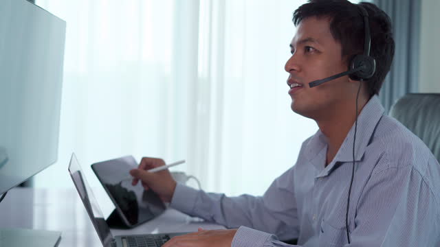Businessman wearing headphones with microphone while talking on call.