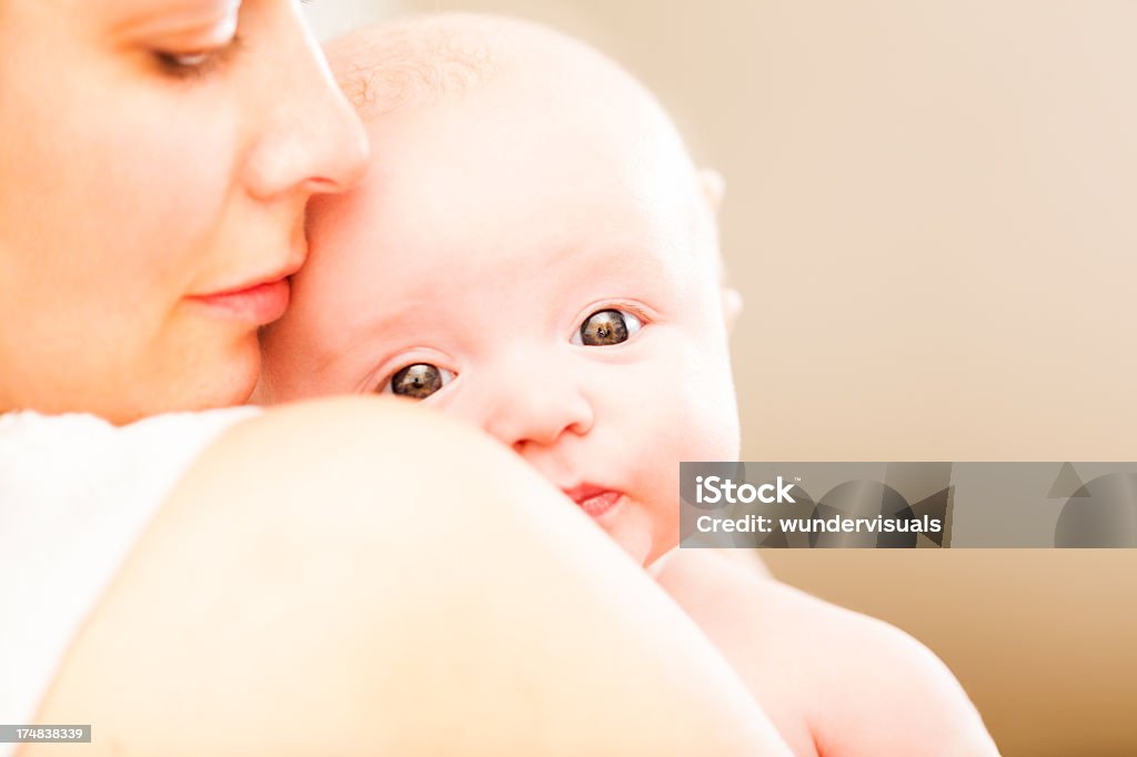 Mother holding baby Caring mother smiling while holding her baby boy.  Baby - Human Age Stock Photo