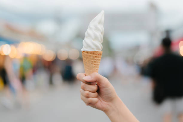 istock hand holding an ice cream cone. 1748383860