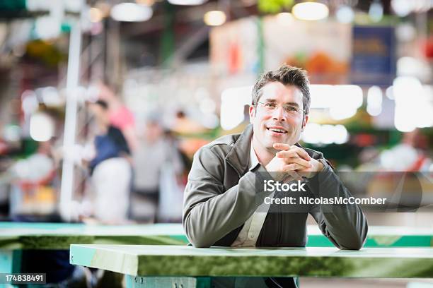 Felice Uomo Seduto Al Tavolo Di Mercato Equo Orizzontale - Fotografie stock e altre immagini di Abbigliamento casual