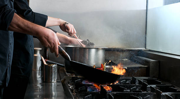 istock chef flambe vegetables in restaurant kitchen 174839016