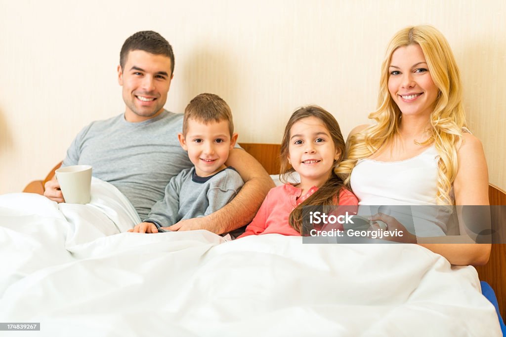Famille profiter de temps ensemble dans un lit - Photo de 25-29 ans libre de droits