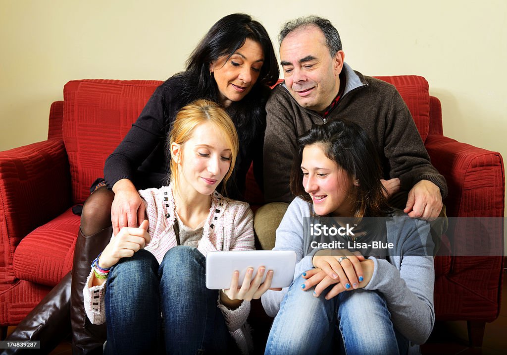 Famiglia felice con Digital Tablet con Sofà - Foto stock royalty-free di Abbigliamento casual