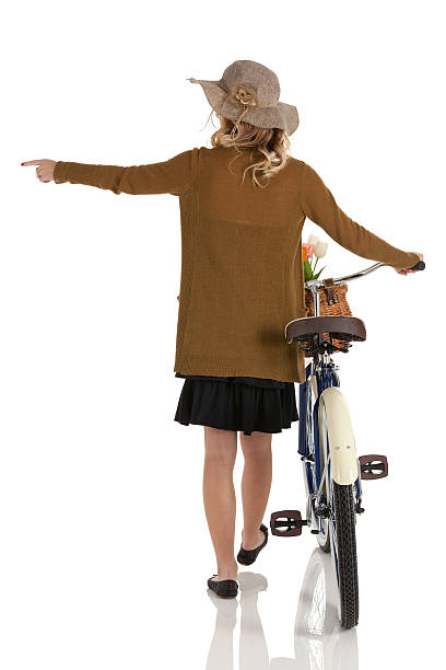 vue arrière d'une femme avec vélo et de montrer du doigt - aiming cycling isolated showing photos et images de collection