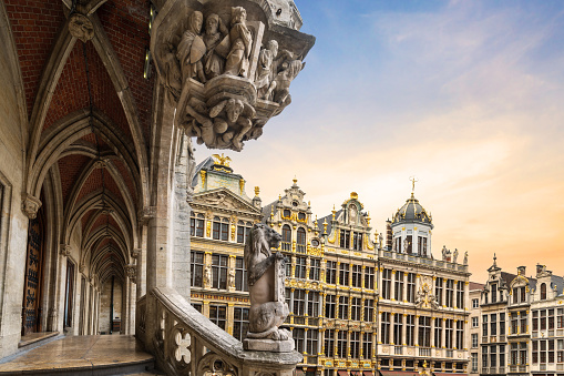 A view of the famous Baroque guildhouses on the Grand Place (Grote Markt) through the architectural details of the historic Gothic-style town hall in Brussels, Belgium