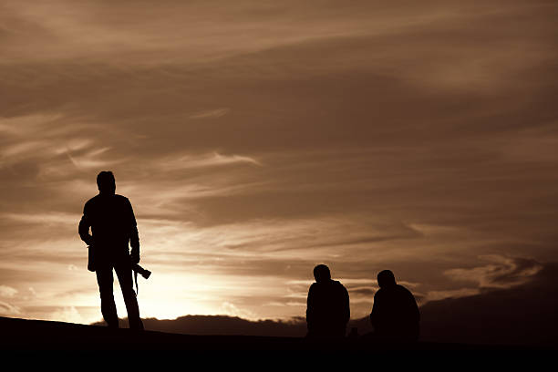 istock Silhouettes of people on orange sky 174839855