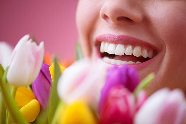 Bella donna sorridente dietro tulipani - foto stock