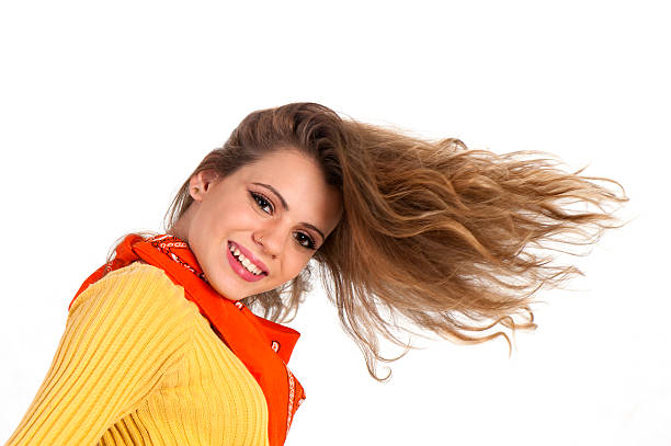 Teenage girl shaking her head and hair against white background. Horizontal composition. Image taken with Nikon D800 and developed from Raw format. Studio shot.