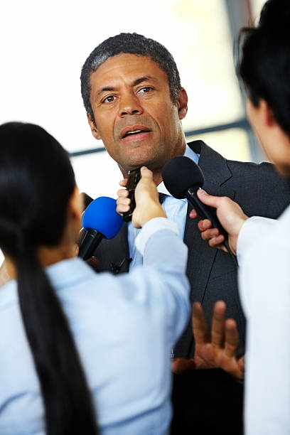 istock Mature male executive being questioned by journalists 174840212