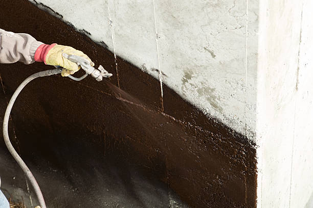 istock Worker Waterproofing a new House Foundation 174840350