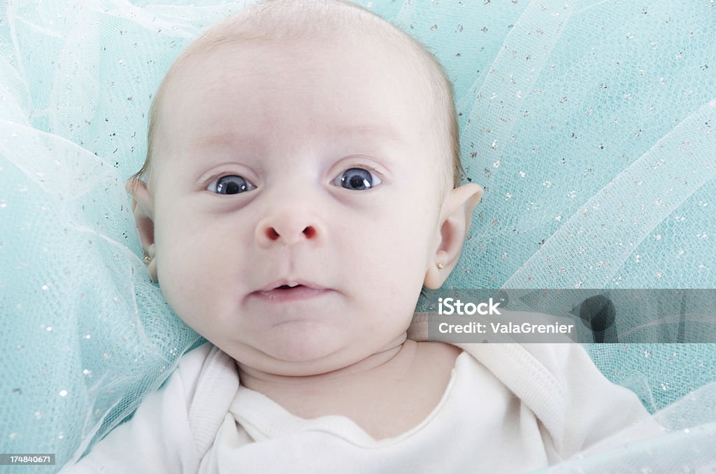 Baby girl on blue chispeante tela mirando a la cámara. - Foto de stock de 0-11 meses libre de derechos