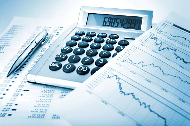calcolatrice con diagrammi e documenti - focus on foreground tax close up finance foto e immagini stock