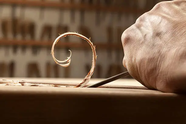 Woodworker carving a wood, close-up,