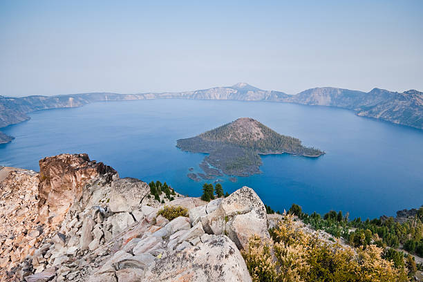 Crater Lake in the Evening Crater Lake exists in the blown-out caldera of a once mighty volcano known as Mount Mazama. This view of the lake and Wizard Island in the evening was taken from Watchman Overlook in Crater Lake National Park, Oregon, USA. jeff goulden crater lake national park stock pictures, royalty-free photos & images
