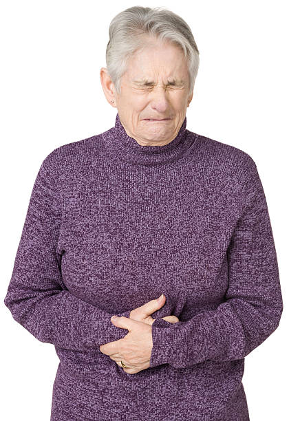 senior femme avec maux d'estomac - indigestion senior adult full purple photos et images de collection